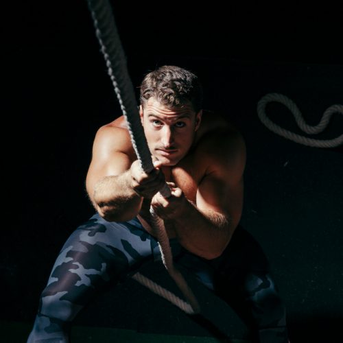 chico estirando del trineo en un programas hibrido de hyrox